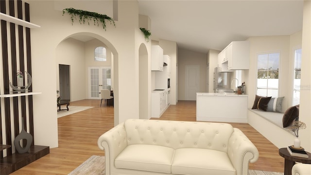 living room featuring arched walkways, light wood-style flooring, french doors, and high vaulted ceiling