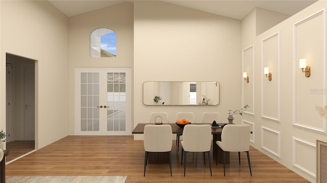 dining area featuring visible vents, french doors, wood finished floors, a decorative wall, and high vaulted ceiling