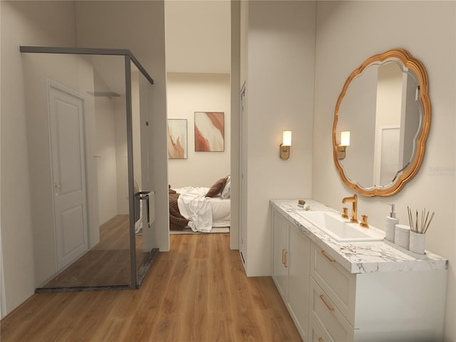 ensuite bathroom with connected bathroom, vanity, a shower stall, and wood finished floors