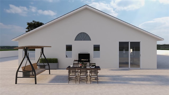 rear view of house featuring a patio and stucco siding