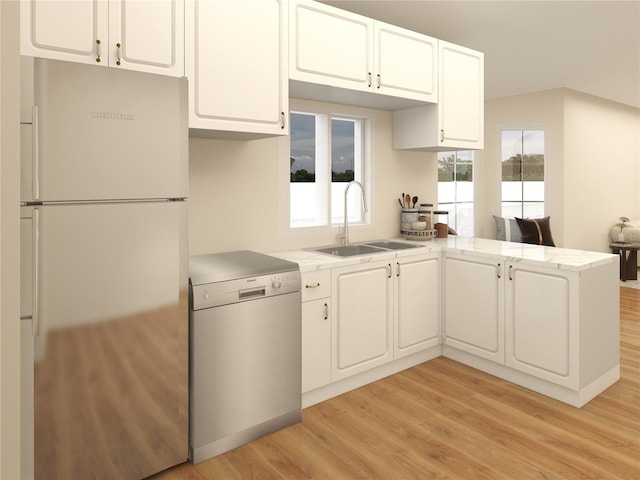 kitchen with dishwashing machine, light wood finished floors, a peninsula, freestanding refrigerator, and a sink