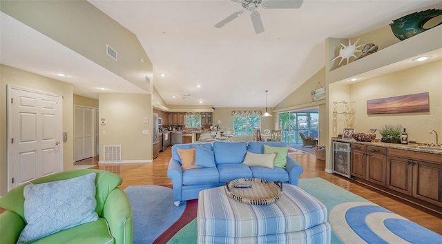 living room featuring high vaulted ceiling, ceiling fan, beverage cooler, dark wood-type flooring, and sink