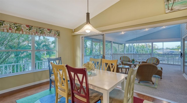 dining room with hardwood / wood-style floors and vaulted ceiling