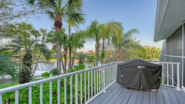 deck with a water view and a grill