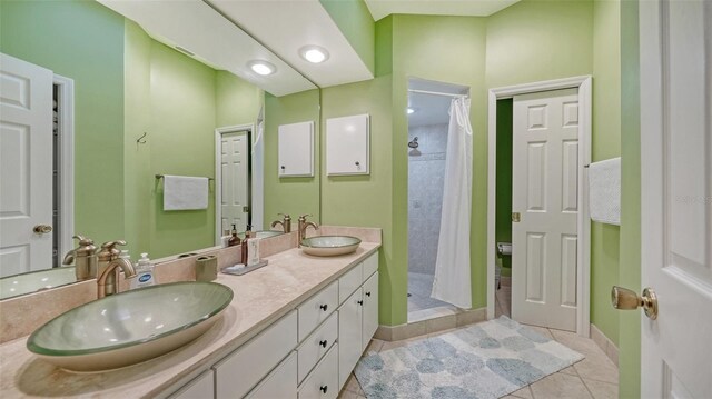 bathroom featuring a shower with curtain, tile floors, and dual bowl vanity