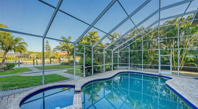 view of swimming pool with a patio, a yard, and glass enclosure