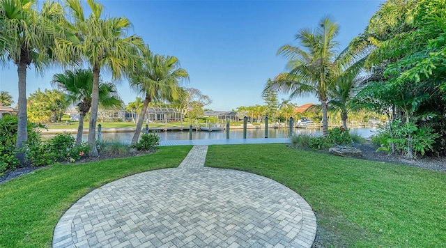 view of property's community featuring a water view, a yard, and a boat dock