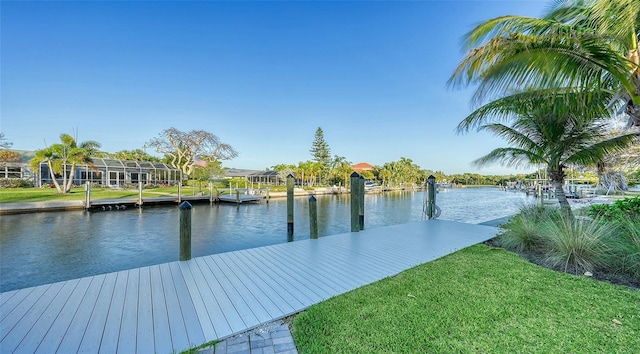 view of dock with a yard and a water view