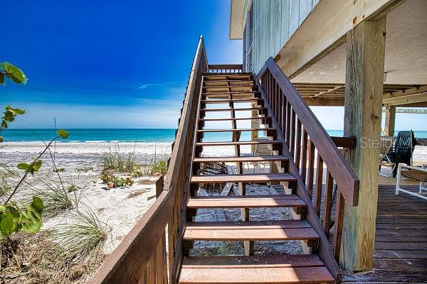 stairs featuring a water view and a view of the beach