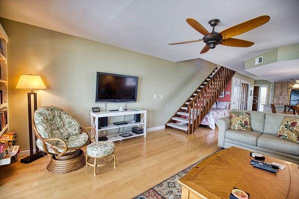 living room with light hardwood / wood-style flooring and ceiling fan