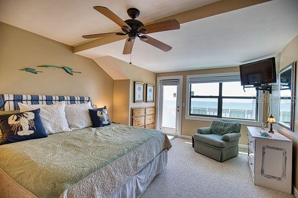 carpeted bedroom with multiple windows and ceiling fan