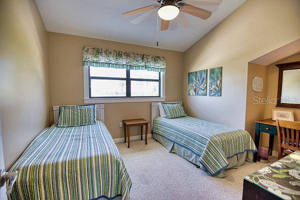 bedroom with light carpet, lofted ceiling, and ceiling fan