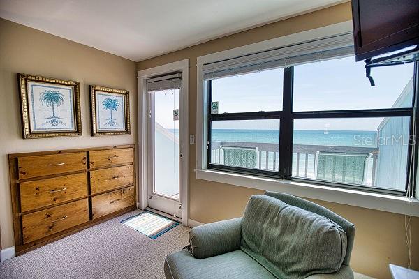 living area featuring light colored carpet and a water view