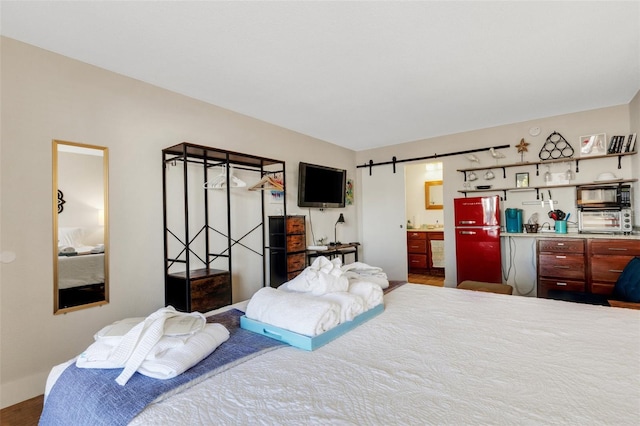 bedroom with ensuite bathroom and a barn door