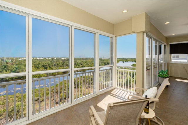 sunroom featuring a healthy amount of sunlight and a water view