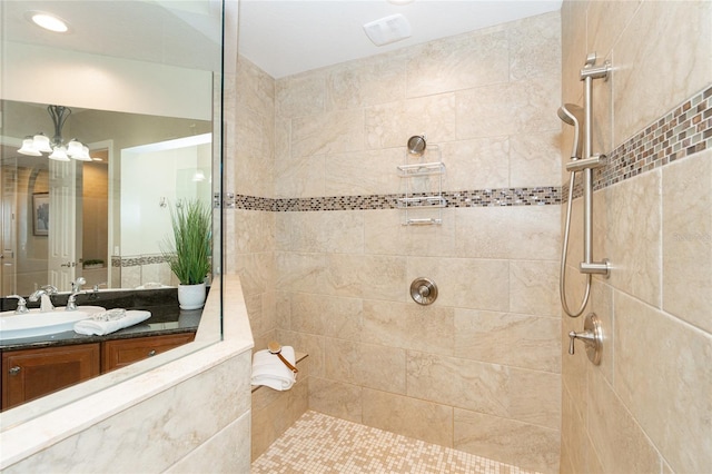 bathroom with vanity and a tile shower