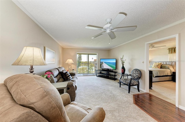 living room featuring light hardwood / wood-style floors, crown molding, a textured ceiling, and ceiling fan