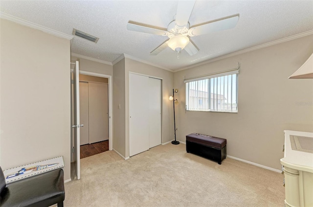 bedroom featuring a closet, ornamental molding, light colored carpet, and ceiling fan