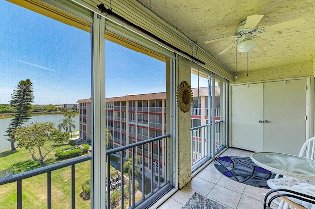 unfurnished sunroom with a water view and ceiling fan