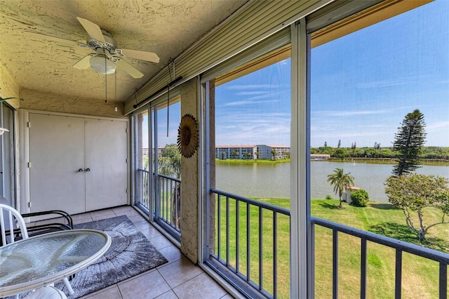 sunroom / solarium featuring a water view and ceiling fan