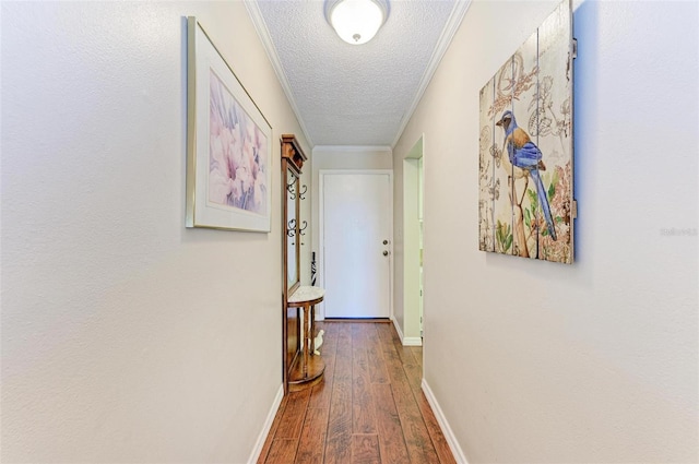 corridor featuring ornamental molding, hardwood / wood-style floors, and a textured ceiling