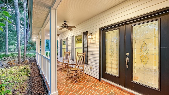 entrance to property featuring a porch and ceiling fan