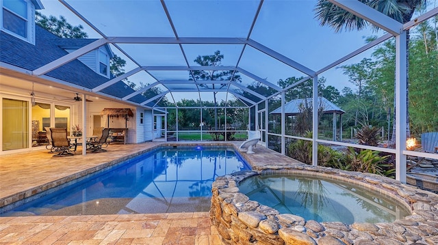 view of swimming pool featuring an in ground hot tub, a lanai, and a patio