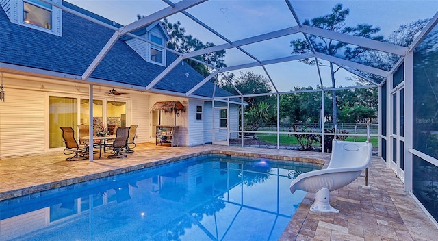 view of pool featuring a water slide, glass enclosure, ceiling fan, and a patio area