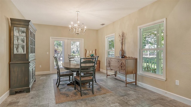 dining space featuring french doors, a chandelier, light tile floors, and a wealth of natural light