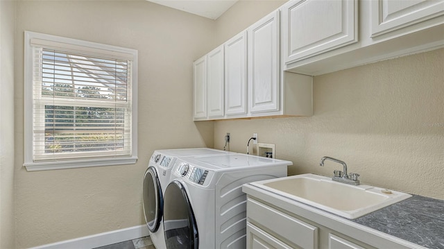 clothes washing area featuring washing machine and dryer, electric dryer hookup, washer hookup, sink, and cabinets