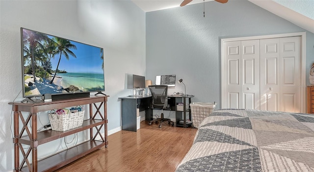 bedroom featuring lofted ceiling, a closet, ceiling fan, and light wood-type flooring