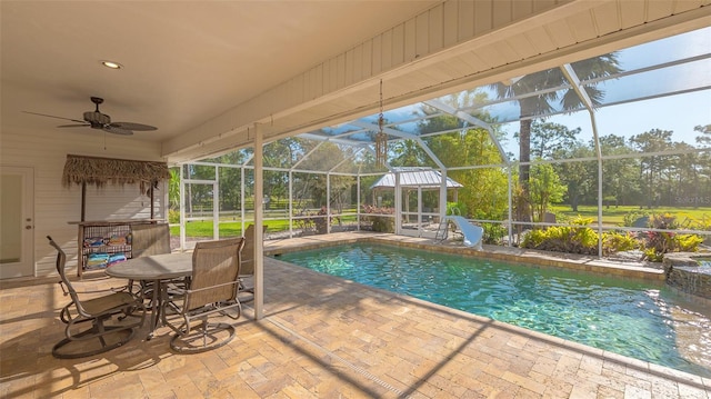 view of pool with a patio, ceiling fan, a lanai, and a water slide