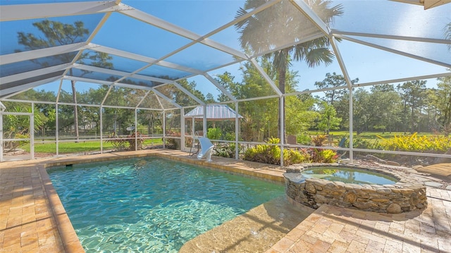 view of pool featuring a patio, glass enclosure, an in ground hot tub, and a water slide