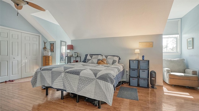 bedroom featuring a closet, light hardwood / wood-style floors, ceiling fan, and vaulted ceiling