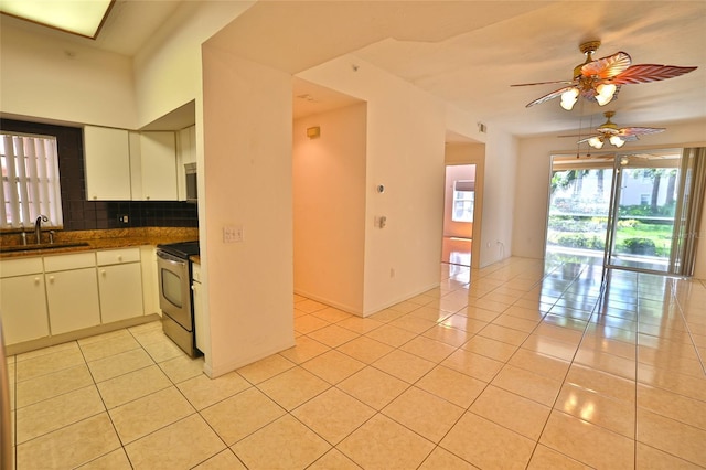 kitchen featuring light tile patterned flooring, electric range, white cabinetry, and sink