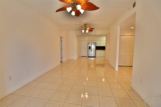 empty room with ceiling fan and light tile patterned floors