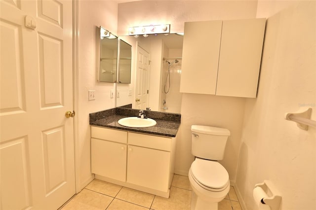 bathroom with toilet, vanity, tile patterned floors, and walk in shower