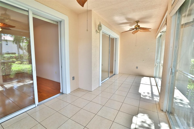 unfurnished sunroom with ceiling fan