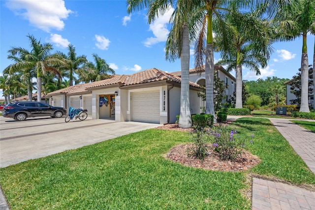 mediterranean / spanish home featuring a front yard and a garage