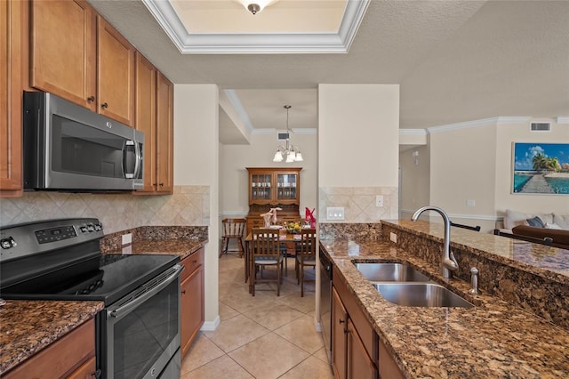 kitchen with dark stone counters, sink, appliances with stainless steel finishes, and a chandelier