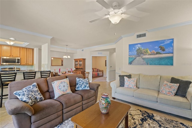 living room with ceiling fan with notable chandelier, ornamental molding, and light tile patterned floors