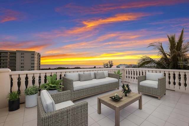 patio terrace at dusk with a balcony and an outdoor hangout area