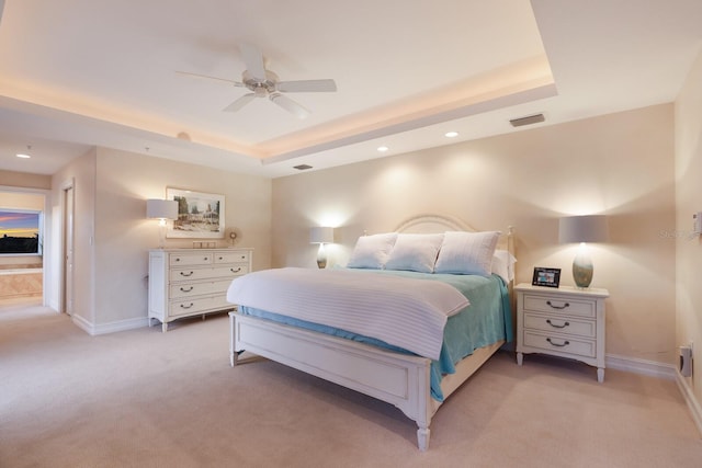 carpeted bedroom featuring ceiling fan and a raised ceiling