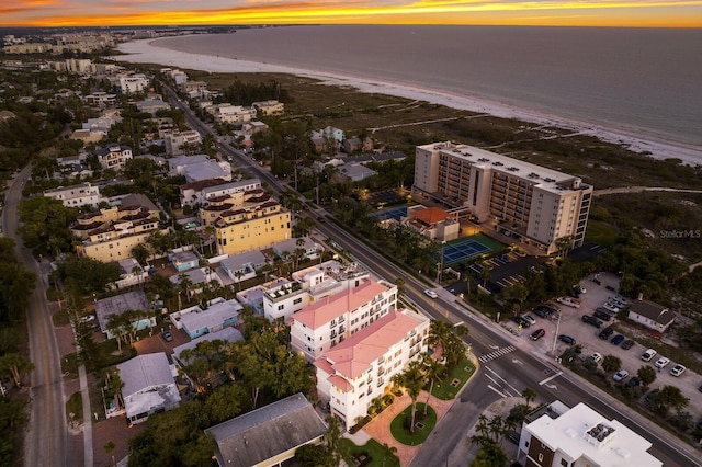 aerial view at dusk featuring a water view