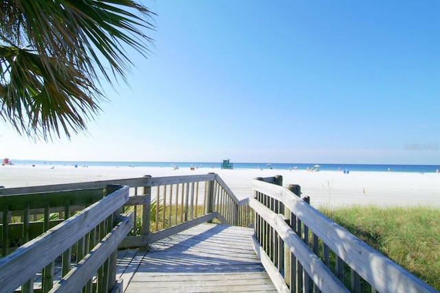 view of dock with a water view and a view of the beach