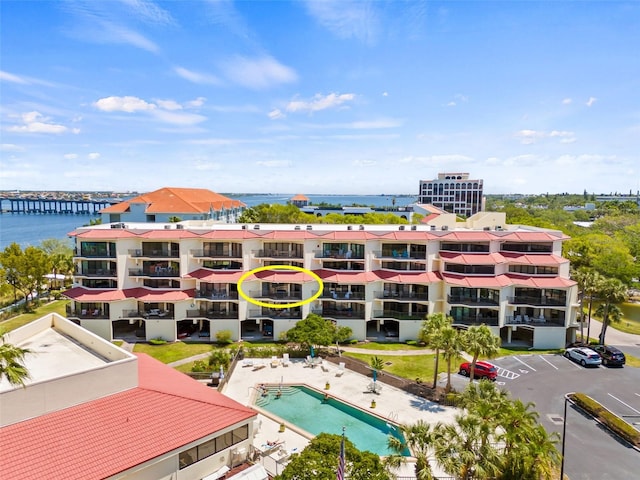 view of building exterior with a water view and a community pool