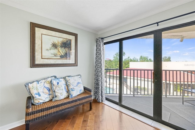 sitting room featuring wood-type flooring, plenty of natural light, and crown molding