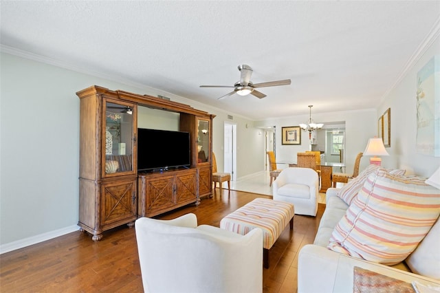 living room with ceiling fan with notable chandelier, crown molding, and hardwood / wood-style floors