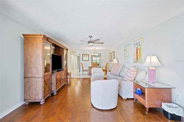 living room featuring ornamental molding, wood-type flooring, and ceiling fan