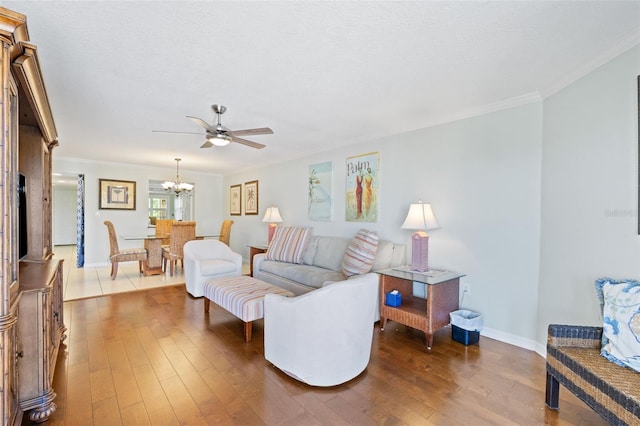 living room featuring hardwood / wood-style floors, ornamental molding, ceiling fan with notable chandelier, and a textured ceiling